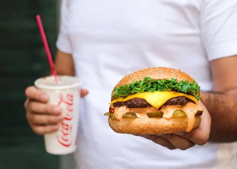 ساندویچ چیزبرگر دوبل آبدار و تازه فست فود شیلا با نان کنجدی، کاهو، پنیر و سس خوشطعم و یک نوشابه.