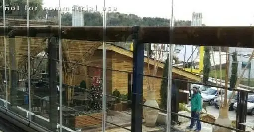 کافی شاپ ویونا پلاس: نمای دلنشین از فضای داخلی به سمت تراس با دکوراسیون چوبی و شیشه‌ای، محیطی آرامش‌بخش و مدرن.