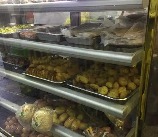 ویترین شیشه‌ای اغذیه فرد بلوار، پر از انواع غذاهای آماده، پیراشکی، سمبوسه و سالاد تازه. انتخاب عالی برای اغذیه و فست فود.