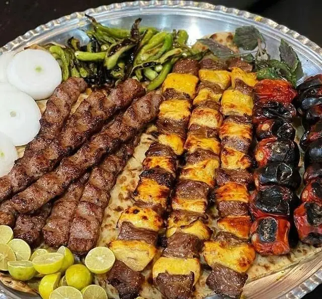 سینی بزرگ کباب کوبیده، جوجه کباب، کباب گوجه و فلفل کبابی با لیمو و پیاز از حلیم و کباب سرای الماس ری، غذای لذیذ ایرانی.
