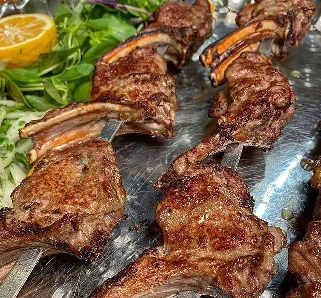 شیشلیک و کباب دنده گریل شده با گوشت تازه و آبدار در حلیم و کباب سرای الماس ری. تجربه‌ای لذیذ از غذای سنتی ایرانی با مخلفات تازه.