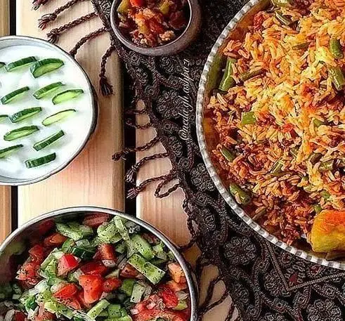 سفره رنگین غذای اصیل ایرانی نازخاتون شامل لوبیا پلو با ته دیگ، ماست و خیار و سالاد شیرازی برای مهمانی و پذیرایی.