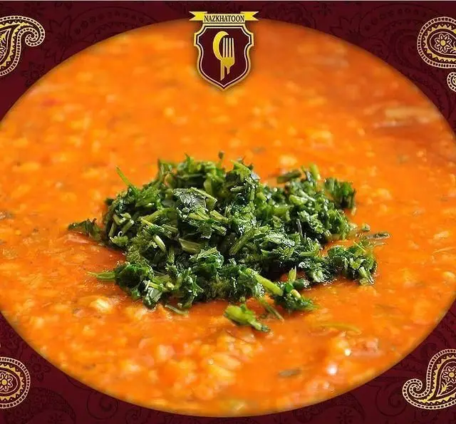 کاسه آش یا خوراک عدسی گرم نازخاتون با سبزیجات تازه و معطر، یک غذای سنتی و سالم ایرانی برای لذت بردن از طعمی بی‌نظیر.