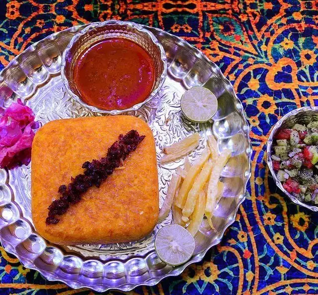 نازخاتون: ته چین زرشک‌پلو مجلسی با دورچین سس، سیب‌زمینی سرخ کرده و سالاد شیرازی. لذت غذای سنتی ایرانی با طعم بی‌نظیر.