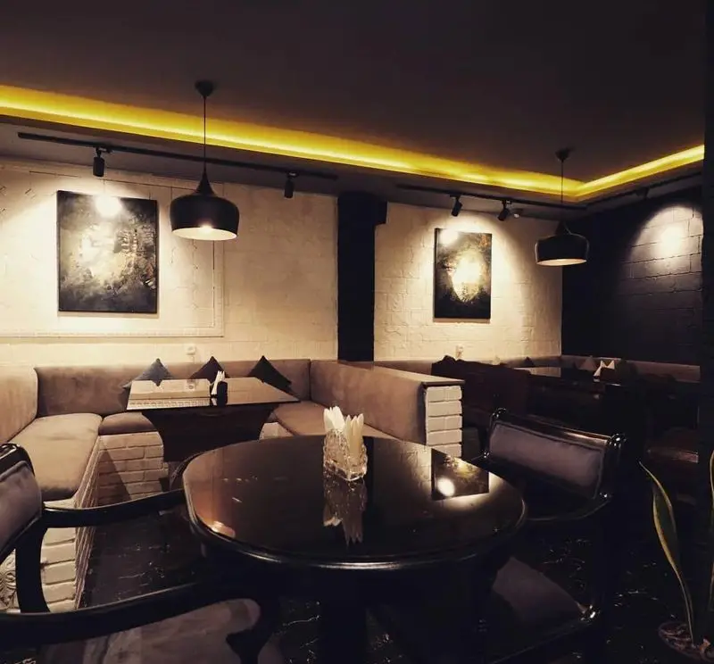 فضای داخلی دلنشین کافه سنتی ژوان با نورپردازی گرم، مبلمان دنج و دکوراسیون مدرن؛ مکانی عالی برای آرامش و لذت.