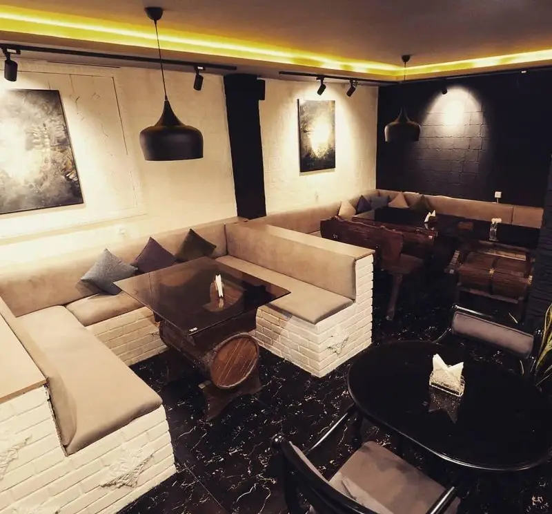 دکوراسیون داخلی کافه سنتی ژوان با تلفیق مدرنیته و سنت، شامل مبلمان راحت، میزهای چوبی و شیک، نورپردازی گرم و محیطی دلنشین.