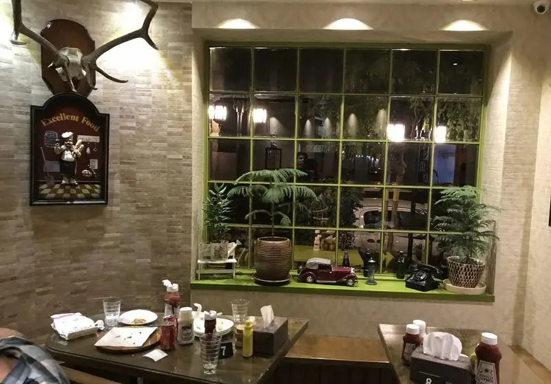 فضای داخلی دنج و جذاب پیتزا بندر؛ با دکوراسیون خاص، پنجره‌ای بزرگ، میزهای غذاخوری و تزئینات منحصربه‌فرد، آماده پذیرایی از مشتریان.