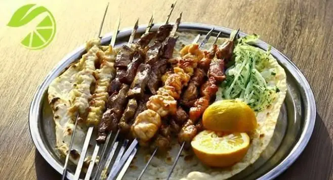 کبابی لیمو ریحون: سینی بزرگ انواع کباب شامل گوشت، مرغ و جگر روی نان تازه با لیمو و سبزیجات. تجربه طعم اصیل ایرانی.