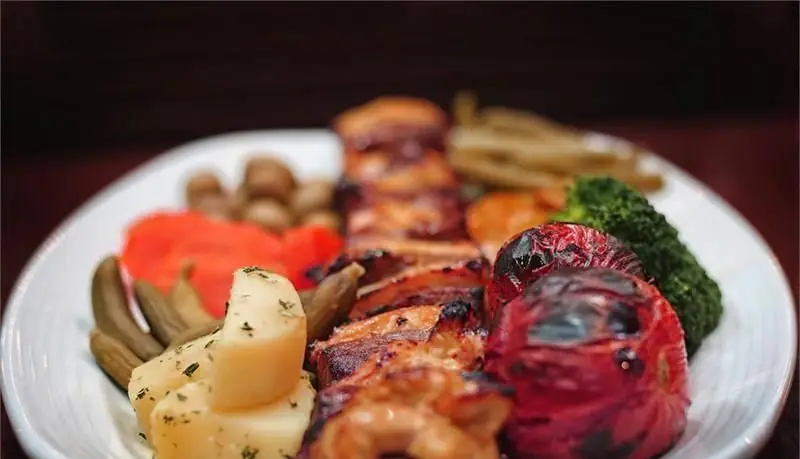 بشقاب غذای لذیذ رستوران مدیا: کباب مرغ آبدار با سیب‌زمینی، گوجه کبابی، بروکلی و سبزیجات تازه. انتخابی عالی برای ناهار یا شام.