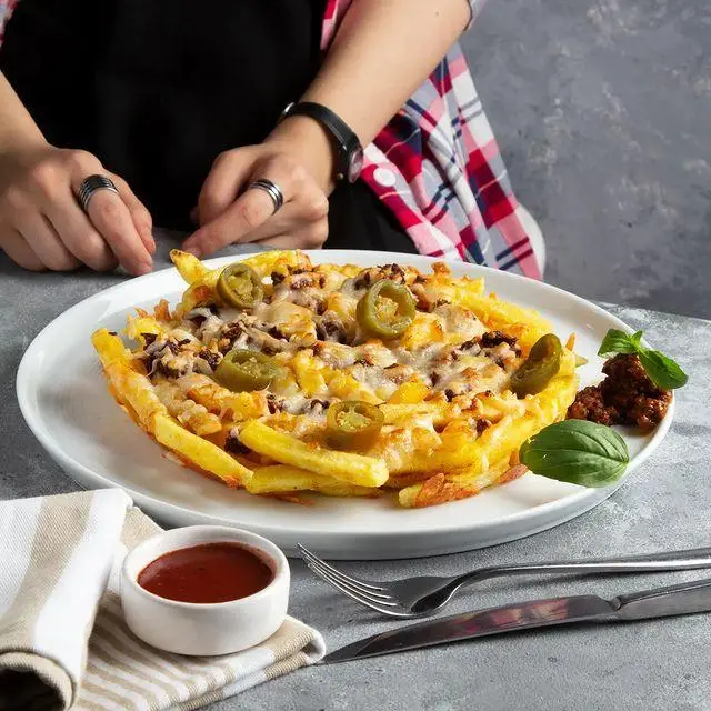 نمایی از سیب زمینی سرخ کرده پرملات با پنیر ذوب شده و هالوپینو، انتخابی لذیذ از منوی کافه و کافی شاپ لیدو پلاس.