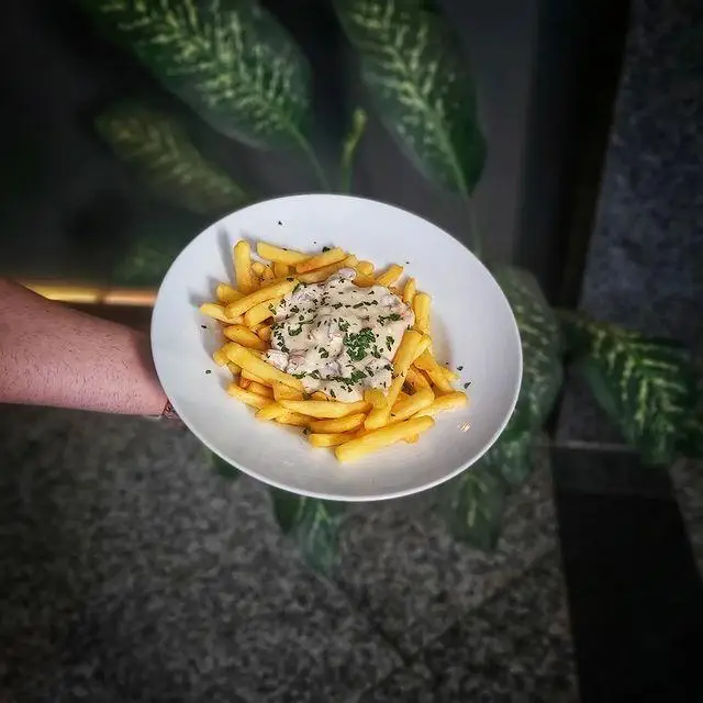 سیب زمینی سرخ کرده خوشمزه با سس قارچ و جعفری، انتخابی عالی برای دورهمی در کافه لیدو پلاس. لذت غذا در کافه و کافی شاپ لیدو پلاس.