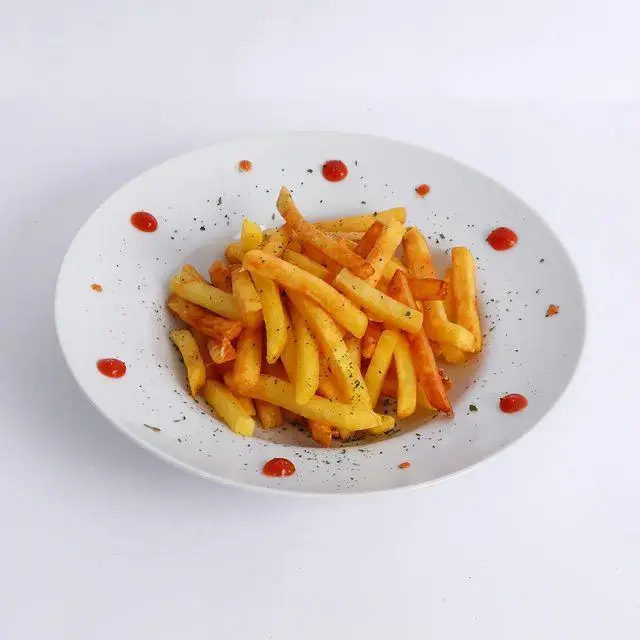 یک بشقاب پر از سیب‌زمینی سرخ کرده ترد و داغ همراه با کچاپ، از منوی پرطرفدار کافه و کافی شاپ لیدو پلاس.