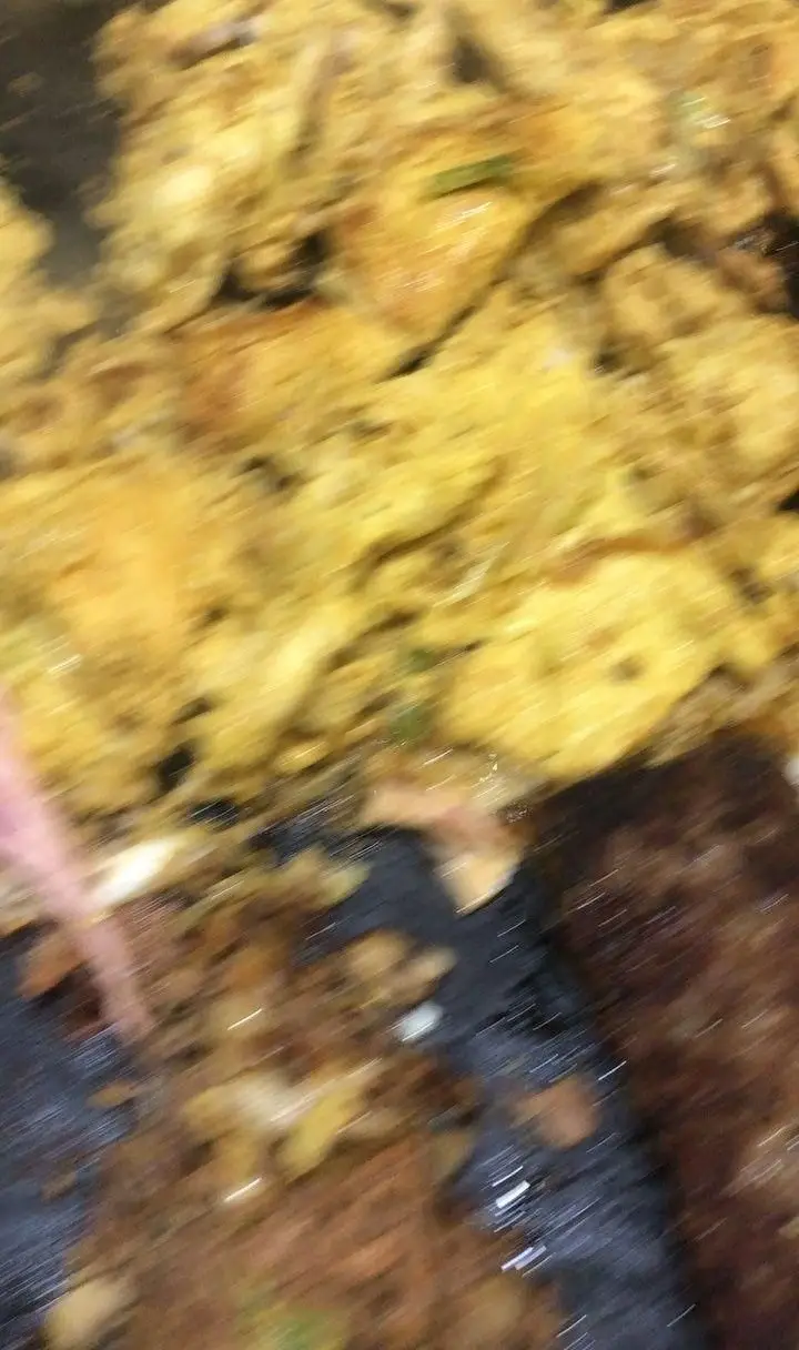 تصویری جذاب از غذای فست فود اژدر زاپاتا، شامل تکه‌های طلایی و لذیذ مرغ یا گوشت در حال آماده‌سازی، با ادویه‌های خوشبو.