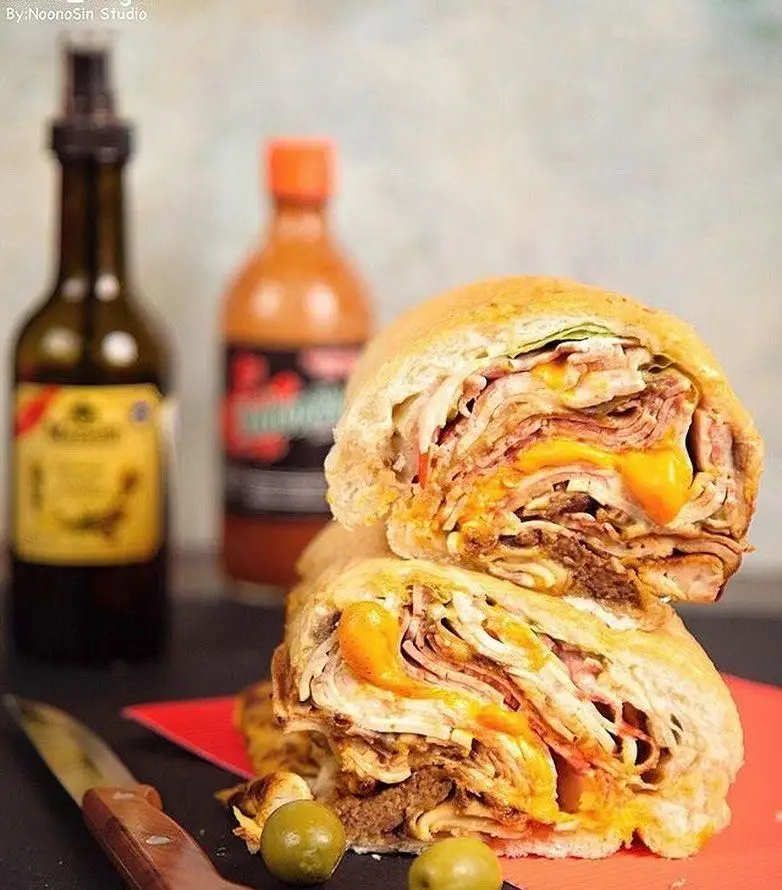 ساندویچ جذاب و پرملات اژدر زاپاتا، سرشار از لایه‌های گوشت، ژامبون و پنیر آب‌شده، یک تجربه لذیذ از فست فود اژدر زاپاتا.