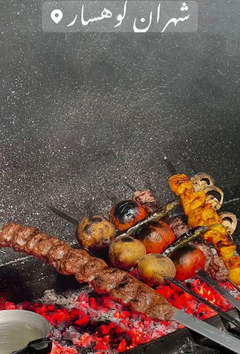 کباب کوبیده و سبزیجات (گوجه، سیب‌زمینی، قارچ) بر روی ذغال گداخته، نمایی از کباب‌پزی در جگرسرای کلبه صحرا.