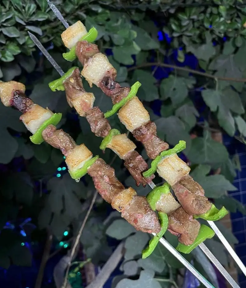 سه سیخ کباب جگر و دنبه آبدار با فلفل سبز، آماده سرو در جگرسرای کلبه صحرا، تجربه طعم لذیذ و اصیل کباب ایرانی.