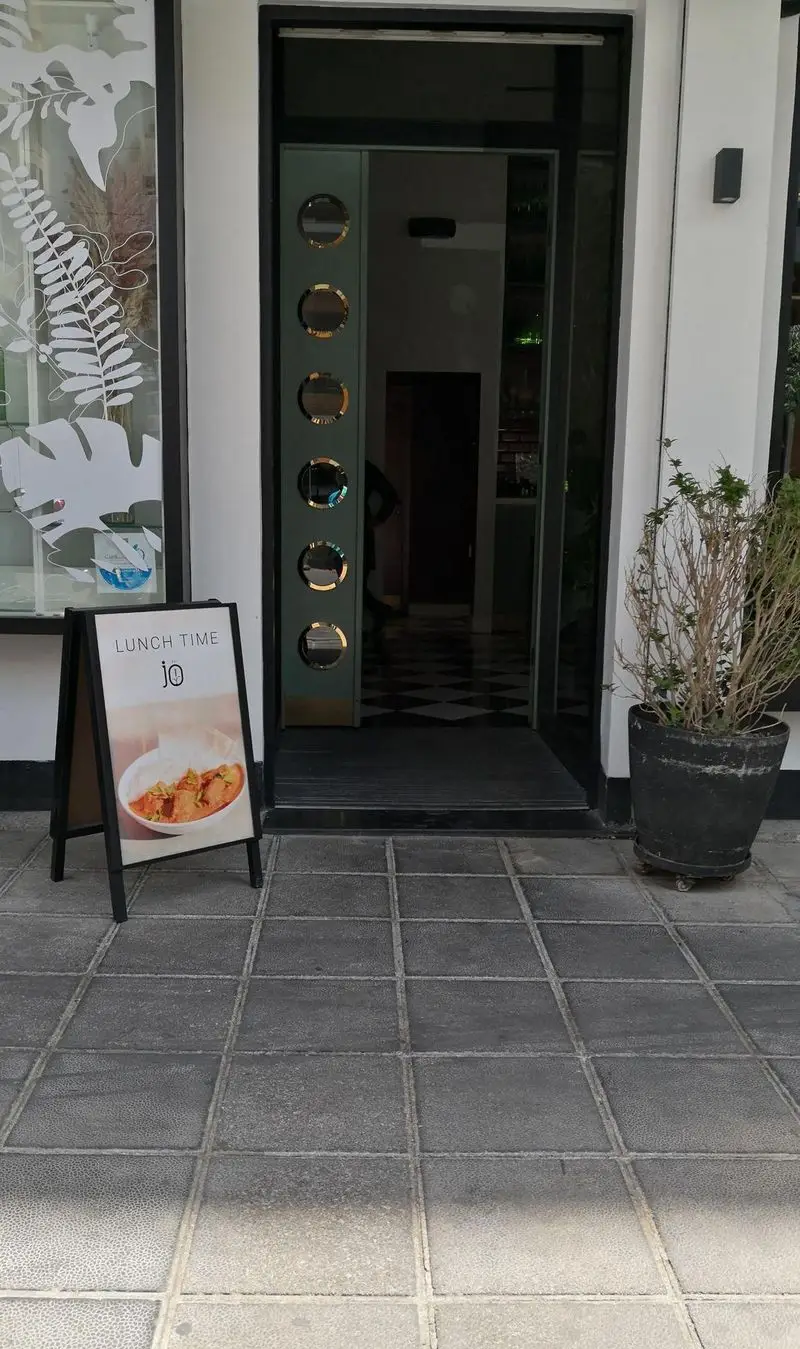 ورودی جذاب رستوران جو با تابلوی "LUNCH TIME"، تصویر غذای لذیذ، مکانی عالی برای یک ناهار خوشمزه و متفاوت.