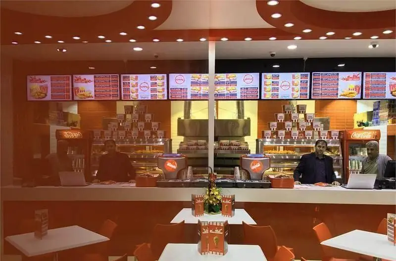 نمای داخلی رستوران کی اف سی هروی، شامل منوهای دیجیتال جذاب، کارکنان در حال کار و فضای پذیرایی مدرن و تمیز این فست فود.