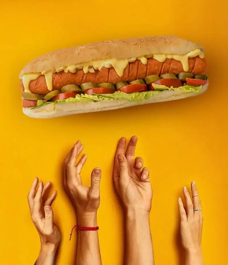 هات داگ سوسیس و پنیر بزرگ و خوشمزه عطاویچ فردوس غرب با کاهو، گوجه و خیارشور؛ یک غذای فست فود عالی و وسوسه‌انگیز.