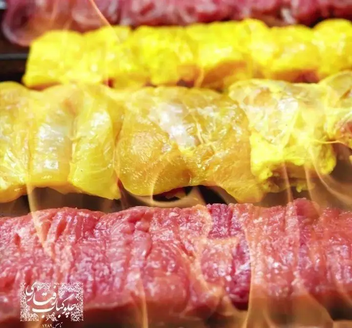 کباب کوبیده و جوجه کباب لذیذ رستوران رفتاری در حال پخت روی شعله‌های آتش. تجربه‌ای خوشمزه از غذای اصیل ایرانی.