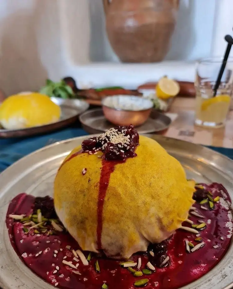 ته چین زعفرانی گنبدی رستوران مس توران با سس آلبالو، کنجد، پسته و خلال بادام، نمادی از طعم بی‌نظیر آشپزی ایرانی.