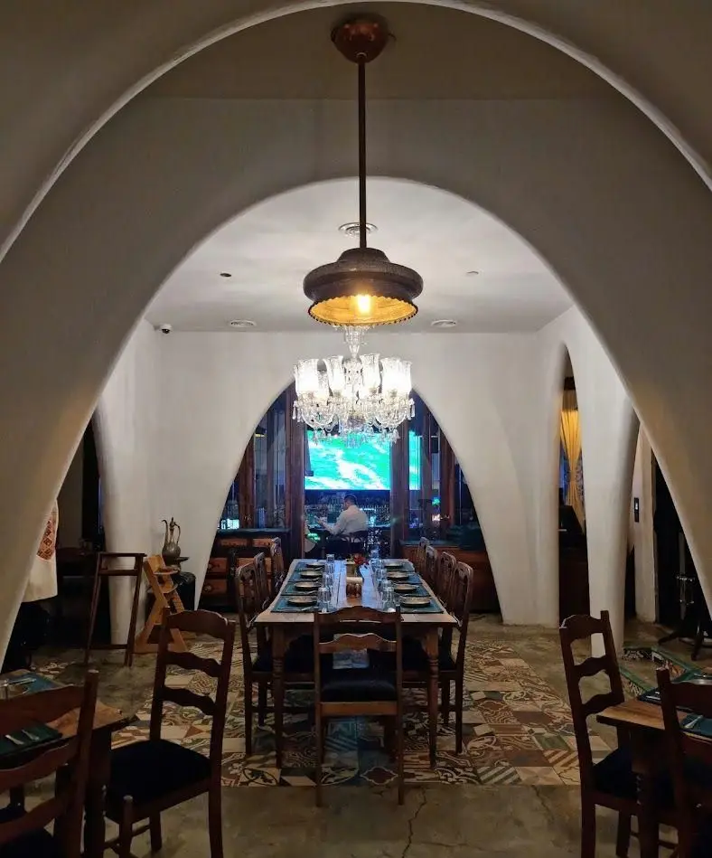 دکوراسیون داخلی چشم‌نواز رستوران مس توران، با طاق‌های منحصر به فرد، لوستر کریستالی، میز پذیرایی بزرگ و کفپوش سنتی طرح‌دار.