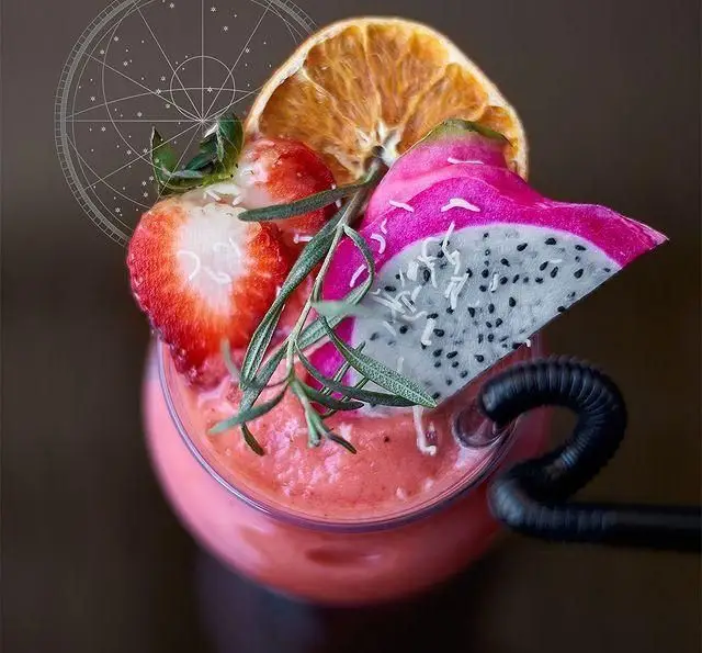 نوشیدنی اسموتی تازه و خوشرنگ مونلانژ با توت فرنگی، دراگون فروت، پرتقال و رزماری، ایده‌آل برای انرژی و طعم متفاوت در کافه رستوران ما.