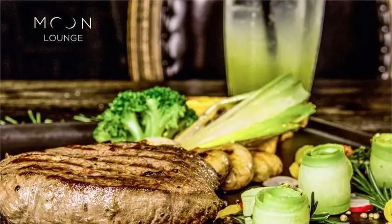 استیک گریل‌شده آبدار با سبزیجات تازه و نوشیدنی خنک در کافه رستوران مونلانژ. تجربه‌ای بی‌نظیر از طعم و کیفیت.