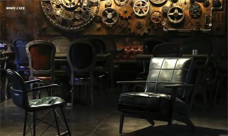 فضای داخلی کافه رستوران مونلانژ با دکوراسیون صنعتی و استیم‌پانک شامل چرخ‌دنده‌ها و صندلی‌های شیک برای تجربه‌ای خاص.