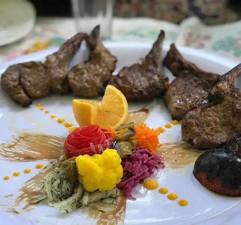 شیشلیک بره رستوران ماه و مهر با دورچین متنوع شامل ترشی، گوجه کبابی و دیزاین زیبا، مناسب ناهار و شام لذیذ ایرانی.