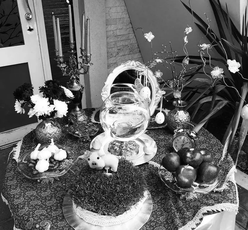 سفره هفت سین باشکوه رستوران ماه و مهر برای استقبال از نوروز و سال نو. با سبزه، تنگ ماهی، آینه، شمع، سیب، سیر و سکه.