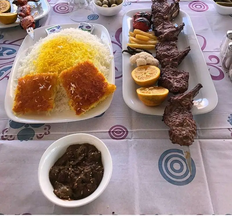 سفره رنگین رستوران ماه و مهر با شیشلیک، کباب، برنج زعفرانی، ته دیگ و خورش فسنجان؛ تجربه‌ای از غذای اصیل ایرانی.