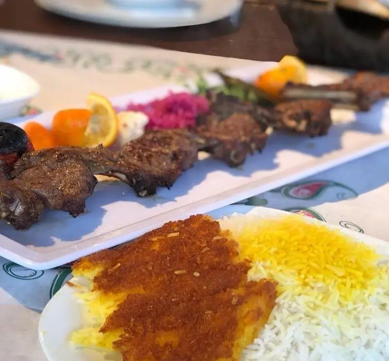 کباب شیشلیک بره رستوران ماه و مهر همراه با برنج ایرانی، ته دیگ زعفرانی و مخلفات. طعم اصیل غذای سنتی ایرانی.
