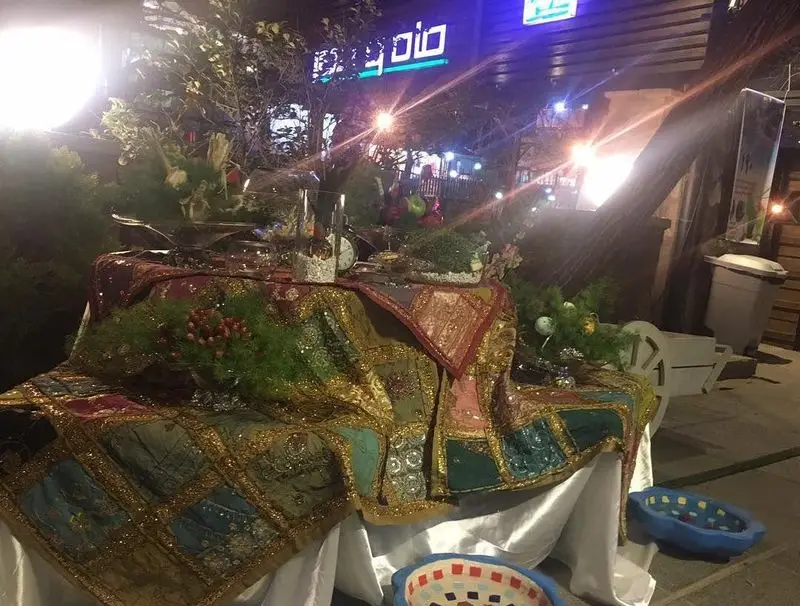 دکوراسیون زیبای شبانه فضای باز رستوران ماه و مهر، با میز هفت سین سنتی و نورپردازی دلنشین برای جشن نوروز.