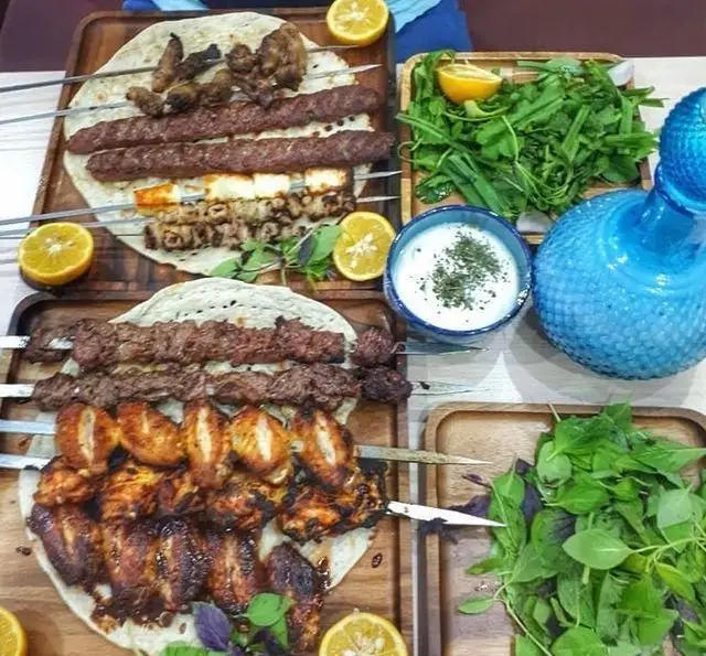 سفره رنگین جگر سرای دل و قلوه؛ انواع کباب‌های لذیذ کوبیده، دل، قلوه، بال و سیخ پنیر کبابی، همراه سبزی و ماست.