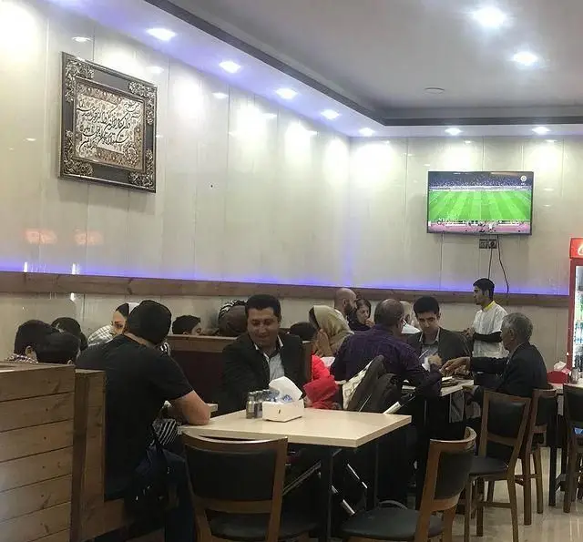 مشتریان در حال صرف جگر و دل و قلوه در فضای داخلی مدرن و دلنشین جگر سرای دل و قلوه، محیطی گرم برای دورهمی خانوادگی.