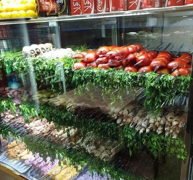 نمایش ویترین جگر سرای دل و قلوه: سیخ‌های کباب جگر، دل، قلوه و گوجه‌فرنگی تازه در کنار سبزیجات معطر، آماده سرو.