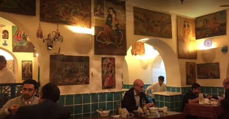 فضای داخلی دلنشین دیزی سرای 110، رستورانی سنتی با دکوراسیون زیبا، نقاشی‌های اصیل ایرانی و مشتریان در حال لذت بردن از غذای دیزی.