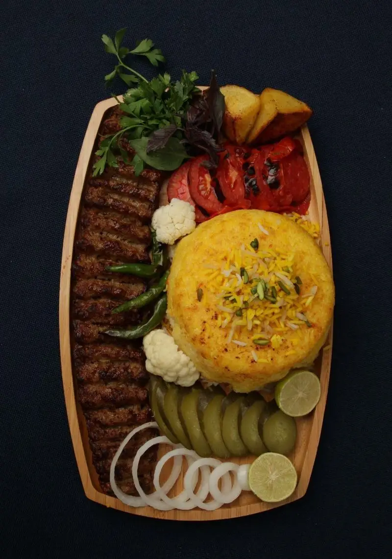 سینی غذای ایرانی لذیذ از کترینگ بزرگ کیبو شامل کباب کوبیده، برنج زعفرانی، گوجه کبابی، سیب‌زمینی و دورچین متنوع