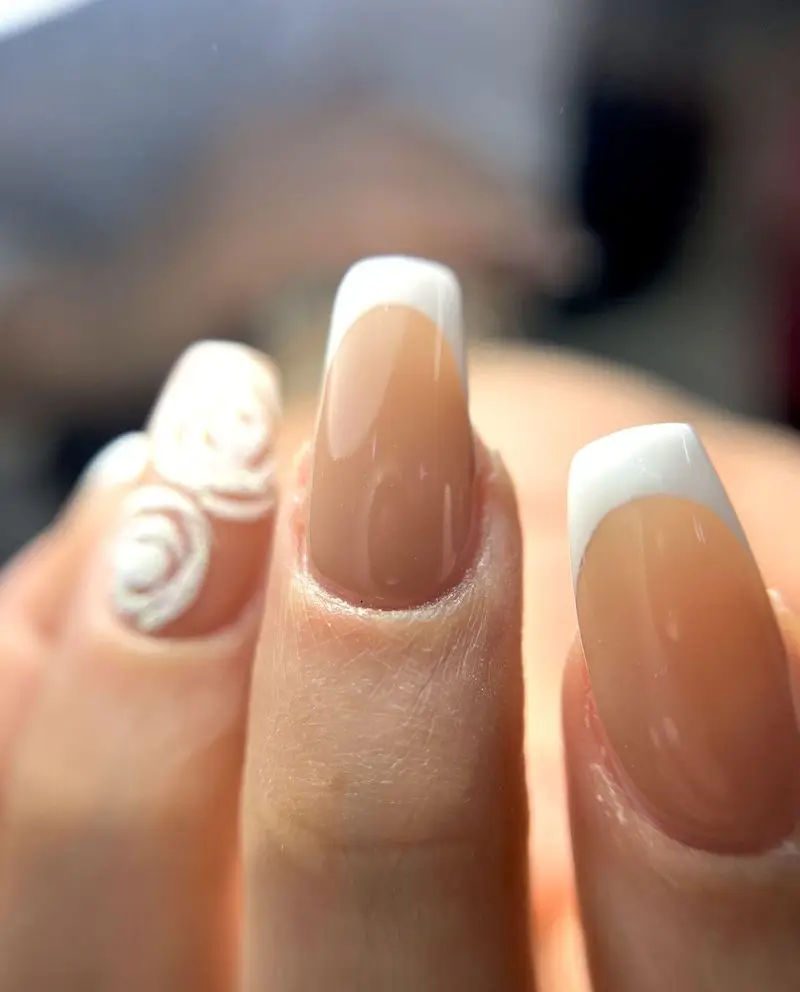 کاشت ناخن فرنچ کلاسیک با لاک ژل سفید و طرح برجسته گل رز سه بعدی روی ناخن‌های بیضی شکل دخترانه برای استایل شیک و ساده