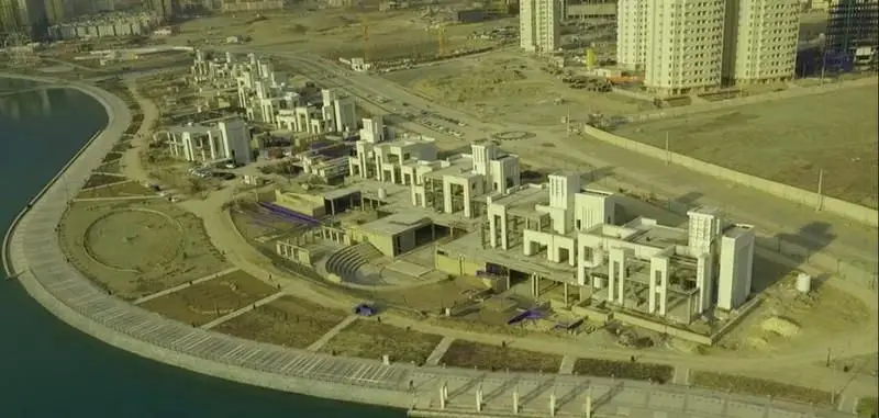 تصویری هوایی از مجموعه تفریحی تجاری بام لند تهران در منطقه ۲۲، شامل اسکله، فضای سبز و ساختمان‌های مدرن کنار دریاچه چیتگر.