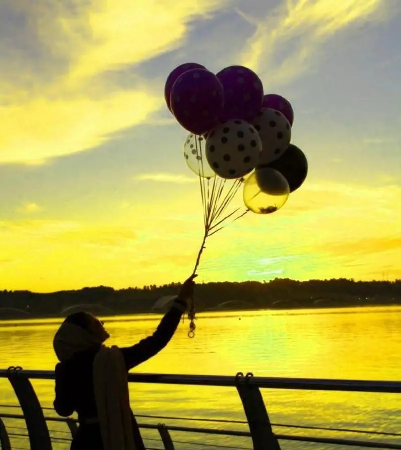 منظره خیره‌کننده غروب طلایی در بام لند تهران، فردی با بالن در کنار دریاچه چیتگر، مکانی ایده‌آل برای آرامش و تفریح.