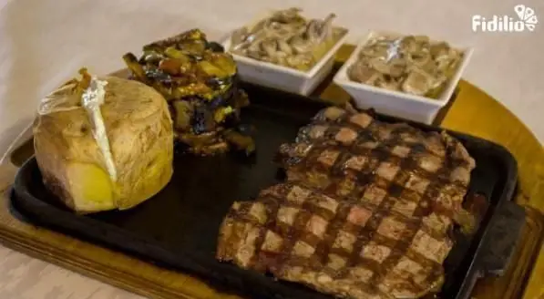 استیک گریل شده آبدار با سیب‌زمینی تنوری، سبزیجات و قارچ‌های طعم‌دار، یک وعده غذایی کامل در رستوران فرنگی شانلی.