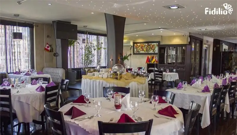 تصویری از فضای دلنشین و شیک رستوران فرنگی شانلی، شامل میزهای غذاخوری آماده با ظروف و بوفه مجلل برای میهمانی‌ها و ناهار و شام.