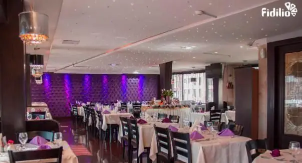 سالن غذاخوری شیک و مدرن رستوران فرنگی شانلی با نورپردازی بنفش چشمگیر، میزهای چیدمان شده و فضایی دلنشین برای پذیرایی مهمانان.