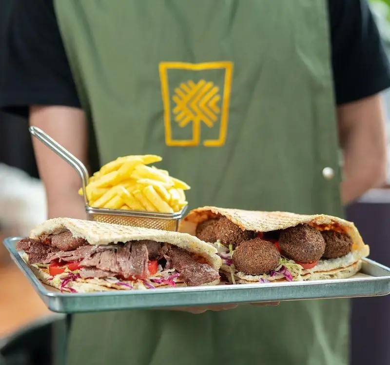 تصویری از ساندویچ‌های لذیذ دونر گوشت و فلافل به همراه سیب زمینی سرخ کرده در فست فود دونر گاردن پاسداران، منوی پرطرفدار.