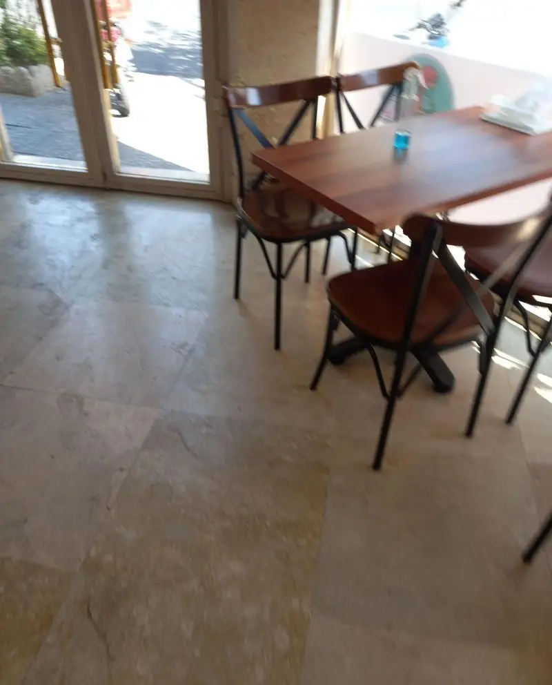 فضای داخلی دنج و مدرن فست فود میلو با میزهای چوبی شیک، صندلی‌های راحت و کفپوش روشن، آماده پذیرایی از مشتریان عزیز.