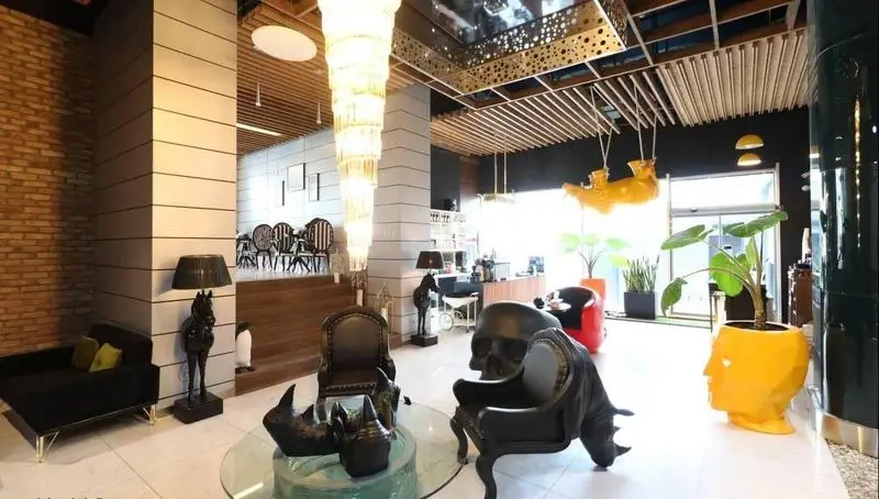 دکوراسیون داخلی شیک و مدرن کافه رستوران پلاس شیم با لوستر عظیم، مبلمان خاص، صندلی‌های هنری و گلدان‌های فانتزی.