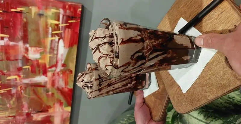 دو میلک شیک شکلاتی خنک و لذیذ در کافه و رستوران تراس لانژ، مناسب برای دسر و تجربه ای دلنشین در فضایی هنری.