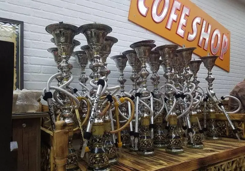 نمای داخلی کافه قلیان و سفره خانه سنتی کولاک با ردیف‌های قلیان نقره‌ای شیک و آماده برای سرو به مشتریان.